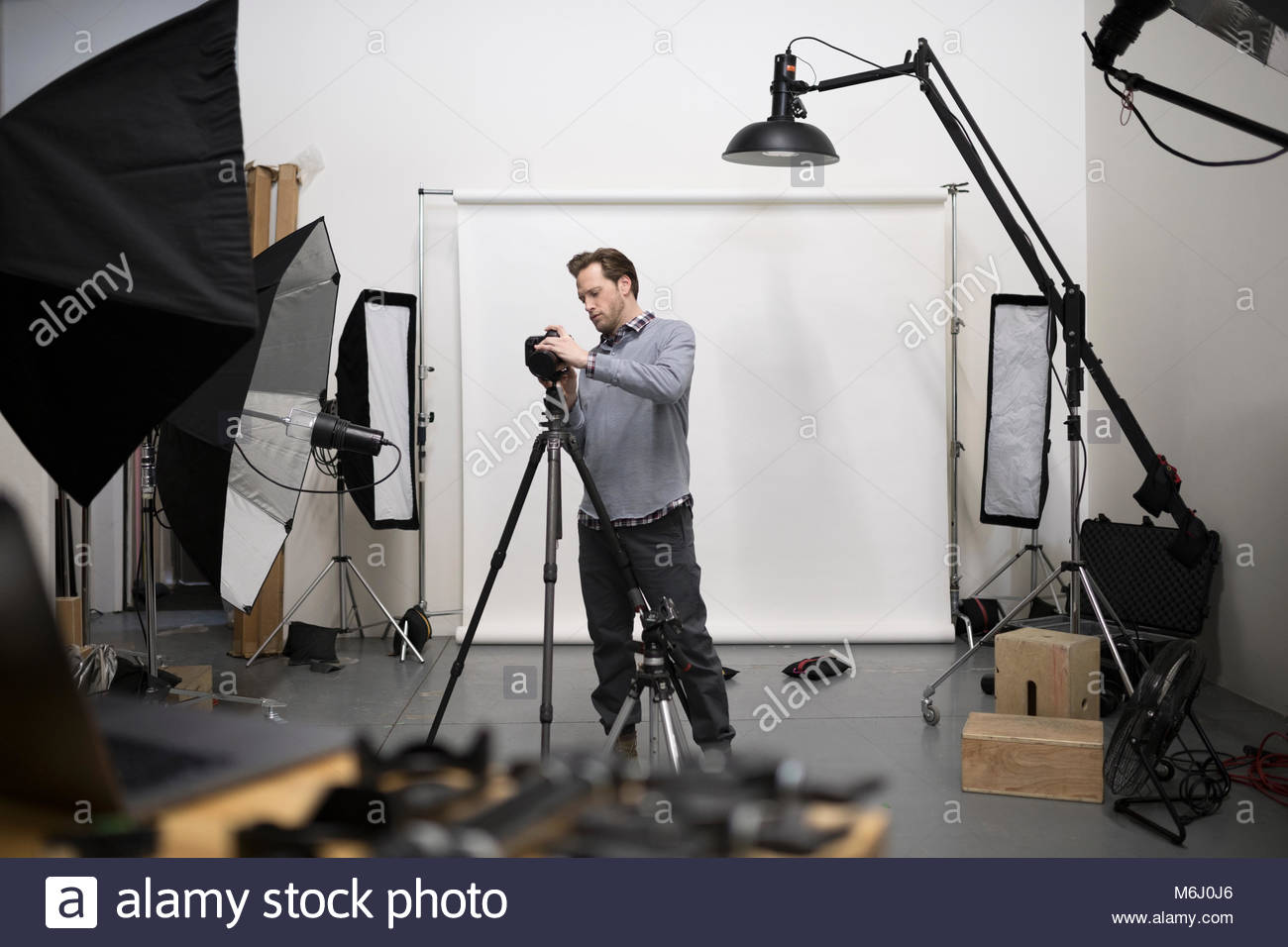 Appareil photo numérique photographe hommes préparer l'équipement pour la séance photo en studio Banque D'Images