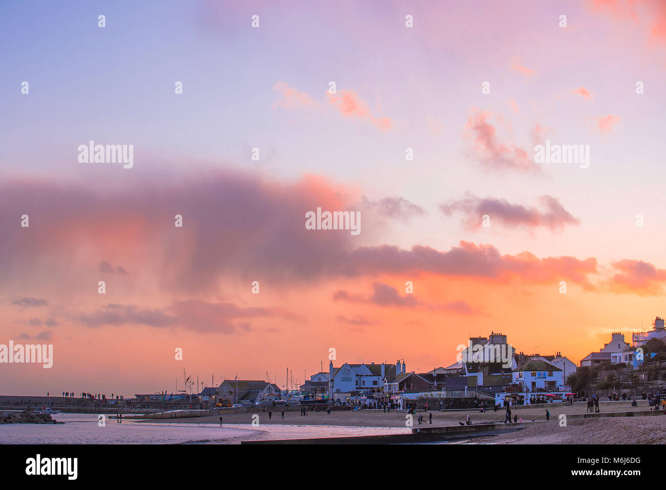 Beaux tons de bleu et orange dans le ciel alors que le soleil se couche sur Lyme Regis en janvier 2018. Banque D'Images