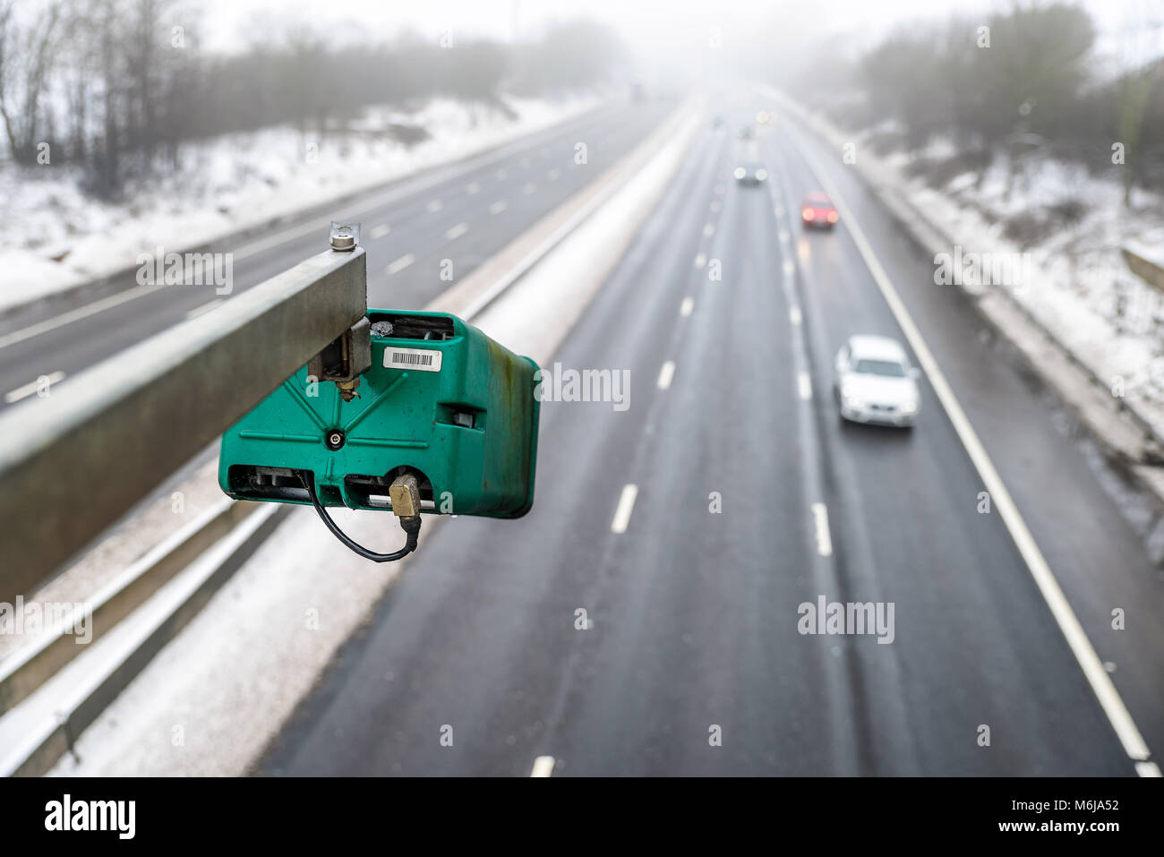 Jour de neige en hiver vue de la vitesse moyenne de l'appareil photo de la circulation sur l'autoroute britannique. Banque D'Images