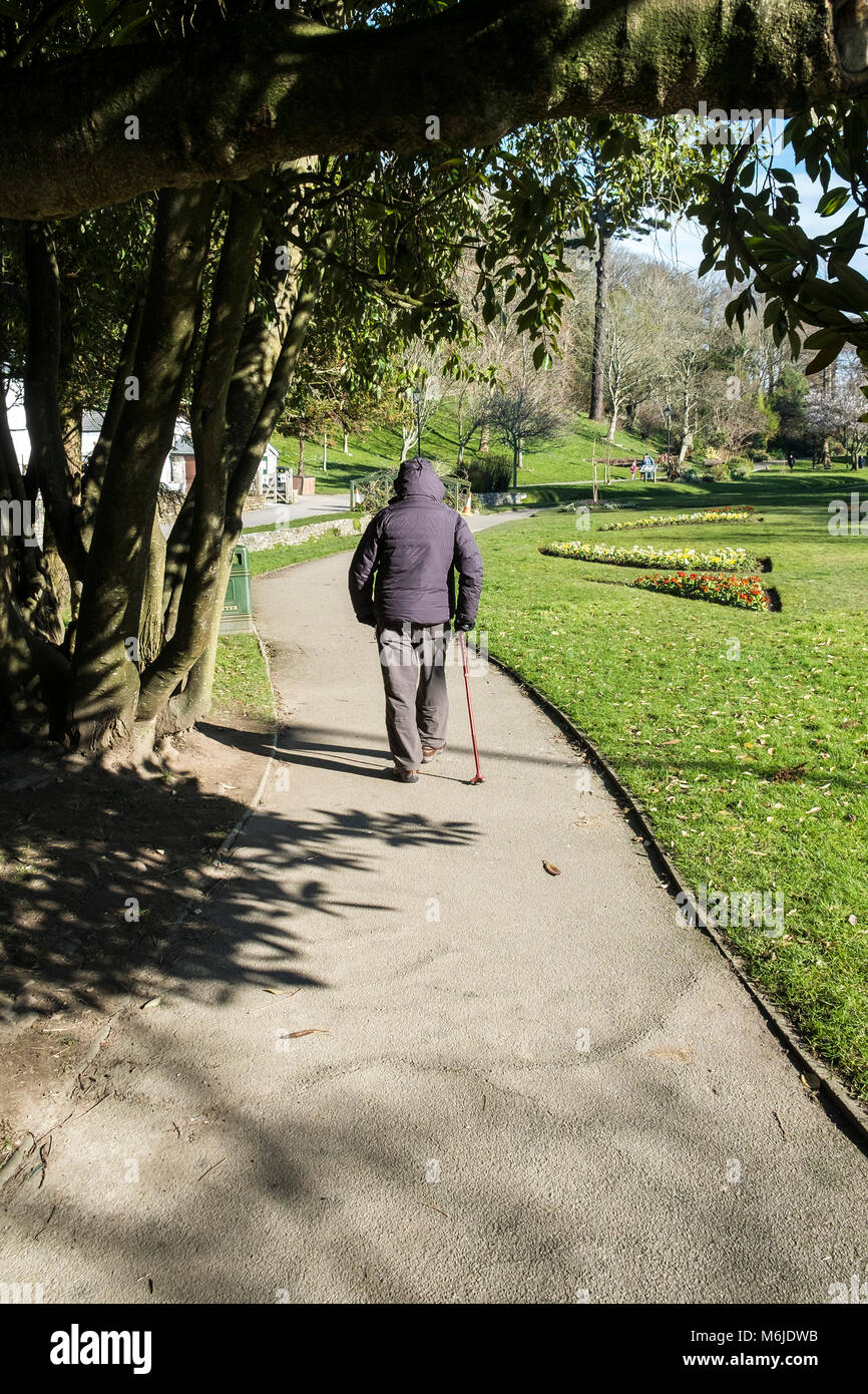 Un homme avec une balade le long d'un chemin dans Trenance Gardens à Newquay Cornwall. Banque D'Images