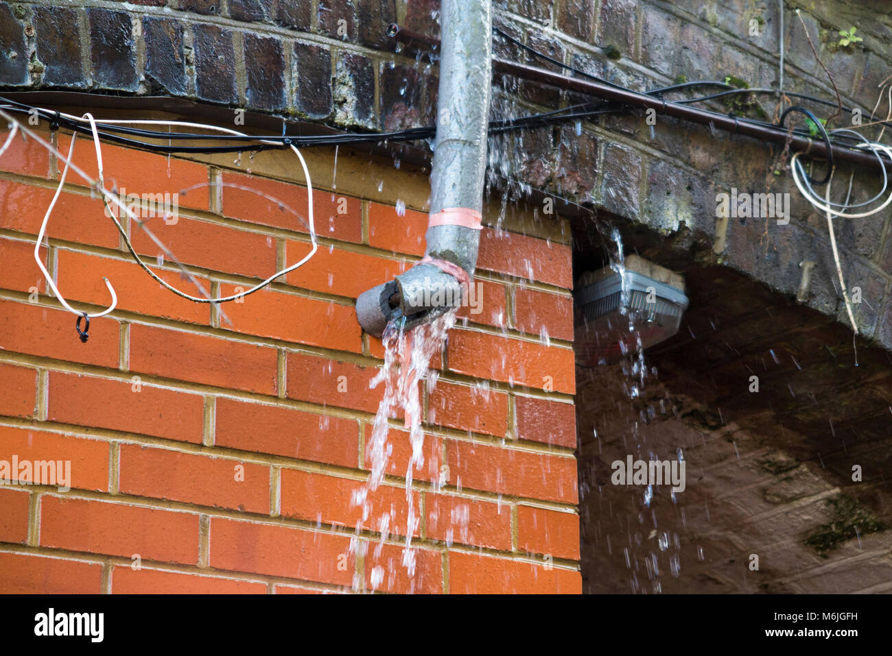 Une fuite d'un tuyau d'eau qui a jailli une fuite dans le dégel après avoir été gelés en jours de forte gelée avec de la neige et des températures sous zéro. UK. Banque D'Images