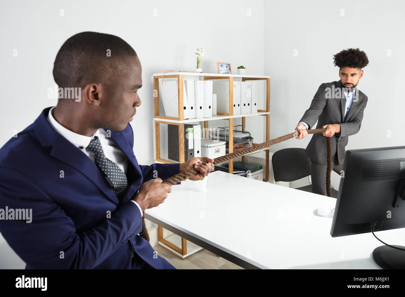 Deux jeunes hommes d'jouer remorqueur de la guerre plus de 24 sur le lieu de travail Banque D'Images