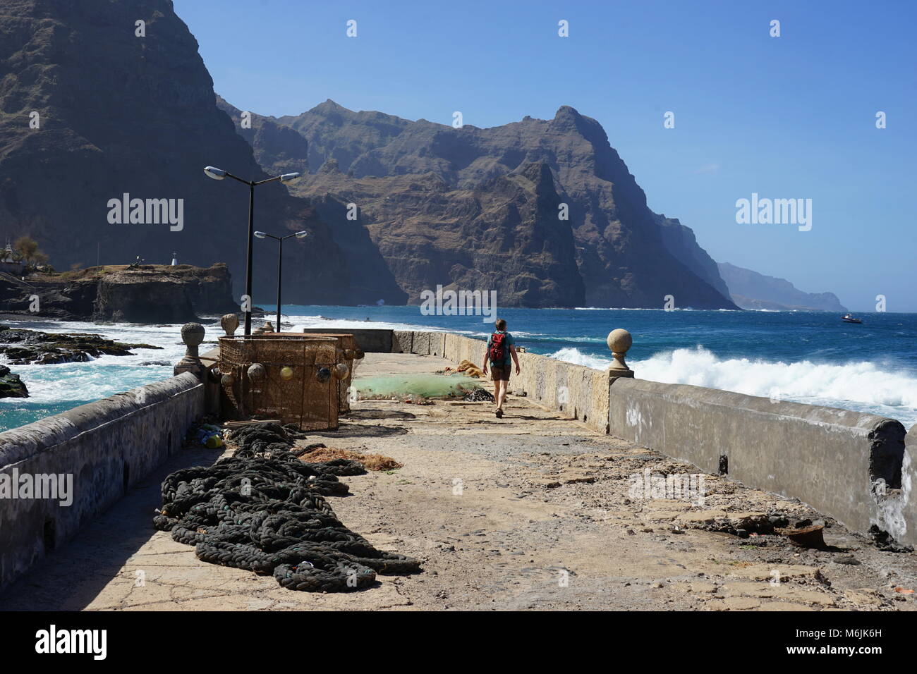 Homme marchant sur le quai du port de pêche "Boca de Pistolas', Ponta do Sol, Santo Antao, Cap Vert Banque D'Images