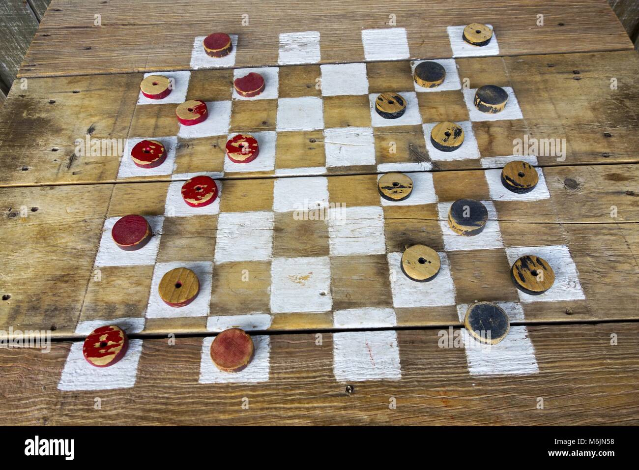 Vintage rustique Antique vieux Checkers en bois table populaire passe-temps jeu de plateau récréatif avec des pièces rouges et noires Banque D'Images