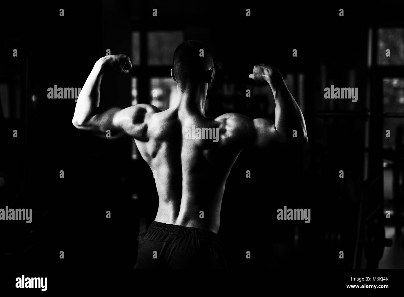 Portrait d'un jeune Nerd Forme Physique Homme montrant son corps bien formé - Athletic musculaire Fitness Model Posing Bodybuilder Exercices après Banque D'Images