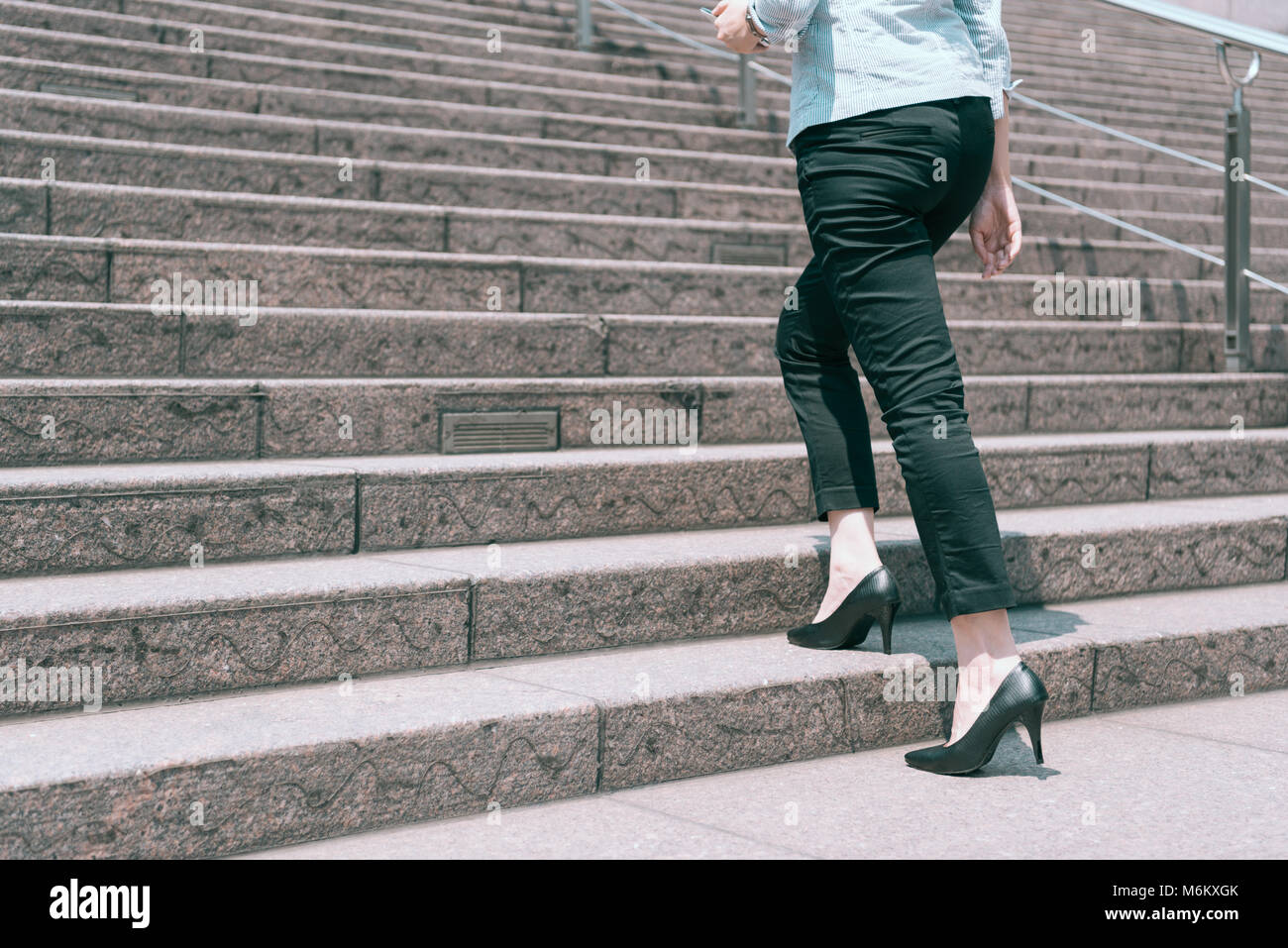 Vue rapprochée de la jambe au pied de hauts talons femme marche sur l'escalier, de la promotion de l'entreprise concept. Banque D'Images