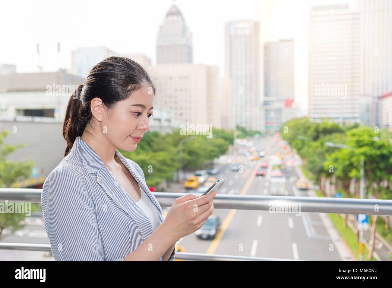 Beautiful businesswoman contrôler l'indice de la qualité de l'air sur l'application pour smartphone en ligne sur l'heure de pointe. Banque D'Images