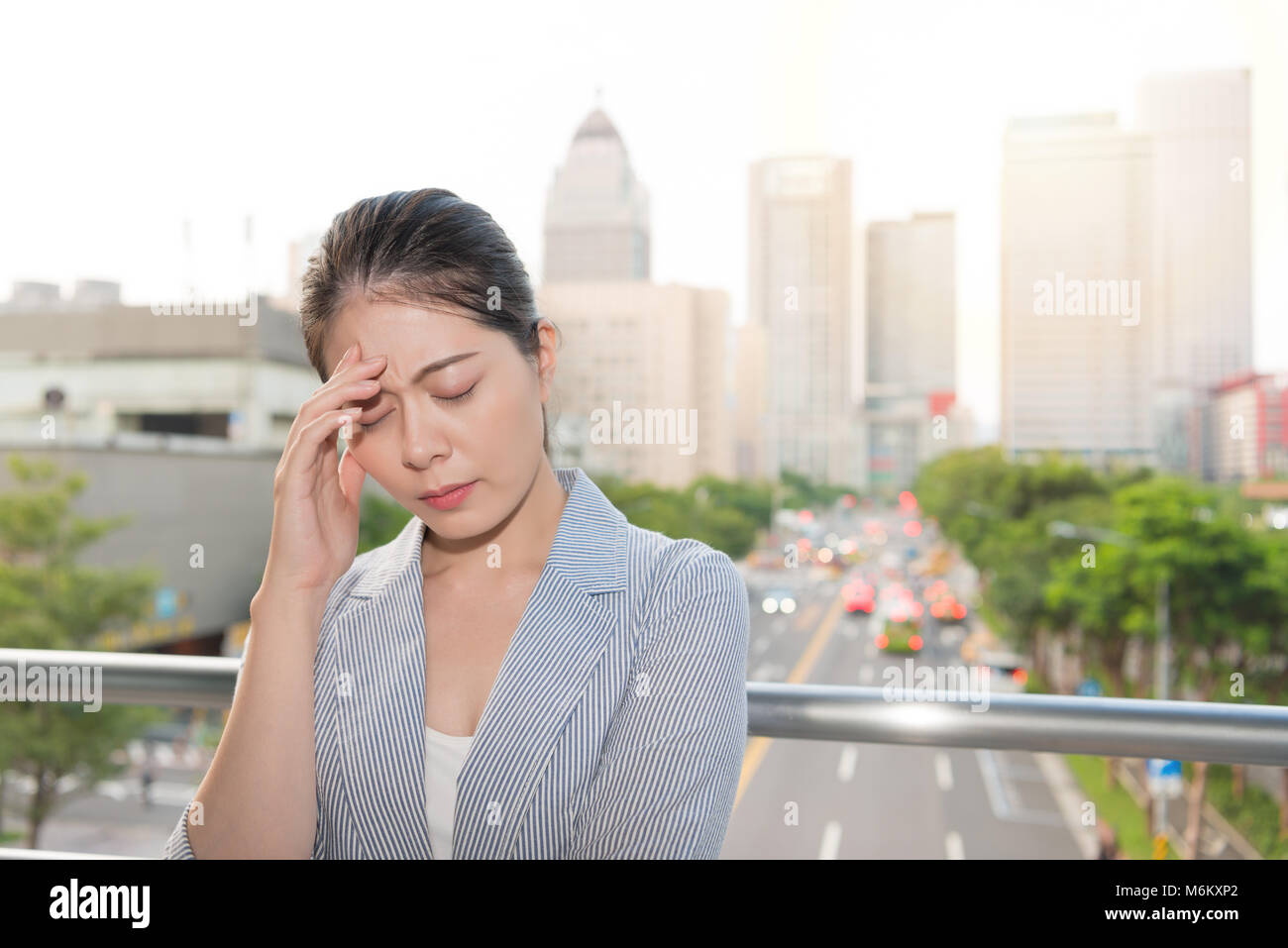 Beau bureau dame se sent un mal de tête douloureux de mal la pollution atmosphérique sur les heures de pointe temps ville. Banque D'Images