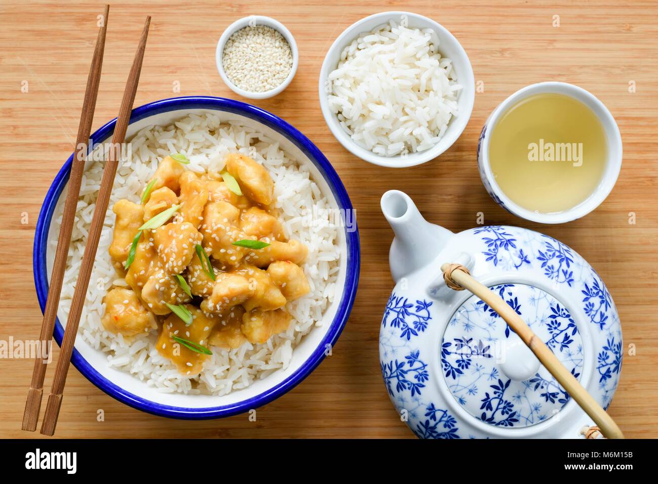 Poulet avec riz orange chinois, Chine théière et tasse de thé vert sur fond de bambou. Vue d'en haut. La cuisine chinoise traditionnelle Banque D'Images