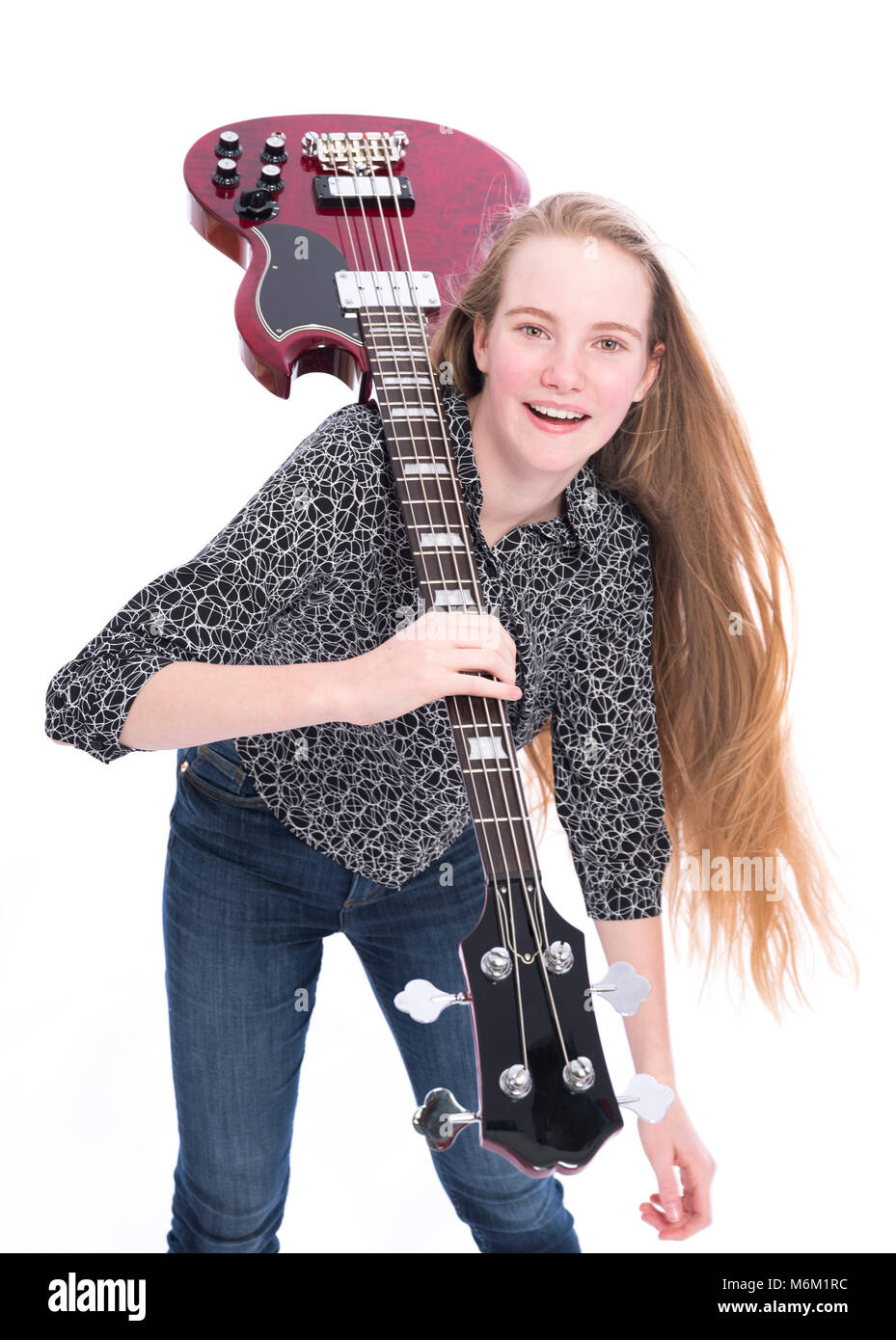 Teen blonde girl et guitare basse contre fond blanc en studio Banque D'Images