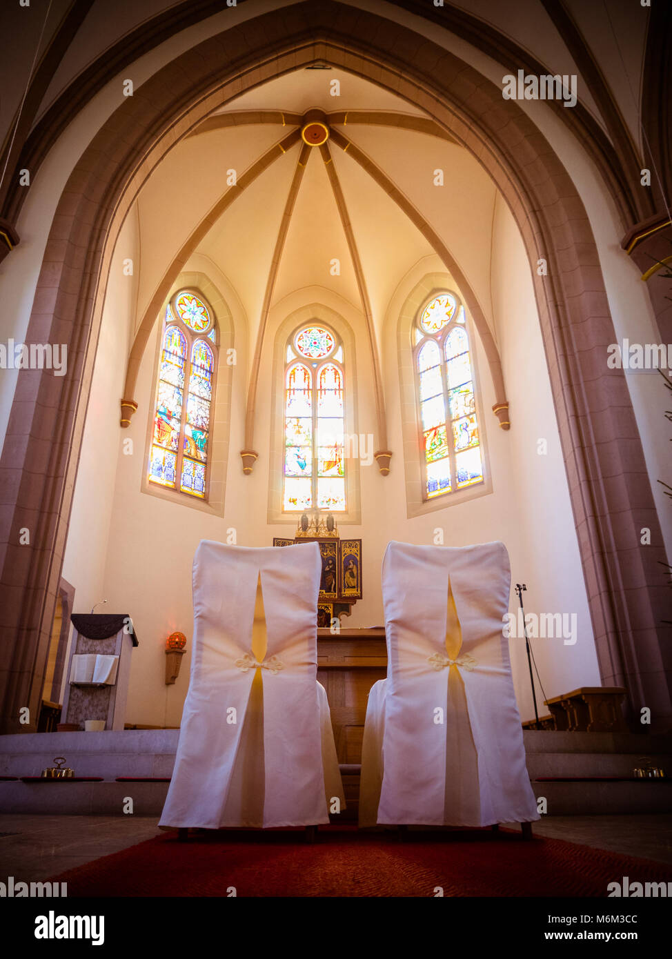 Des chaises dans l'église pour la cérémonie du mariage à l'autel Banque D'Images