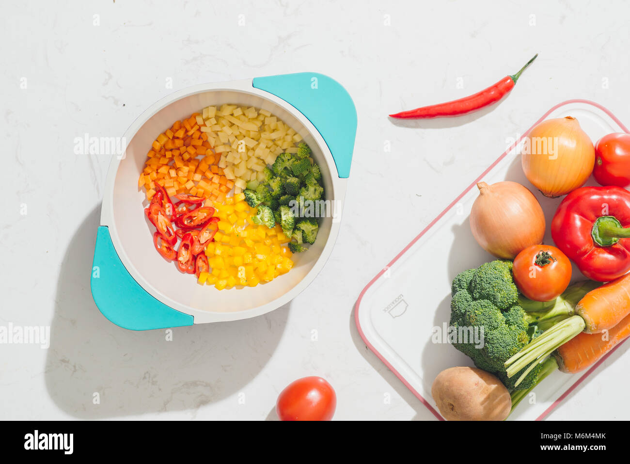Légumes hachés sur pot et savoureux ingrédients pour la cuisine végétarienne. Vue d'en haut. Banque D'Images