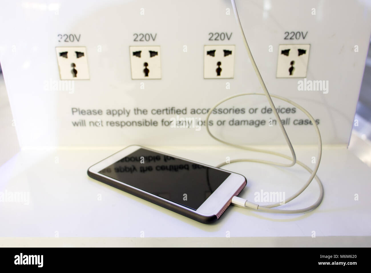 Station de charge de la batterie gratuitement à l'aéroport de la Traveler. De charge de téléphone sur une table à un point de recharge dans le hall. Banque D'Images