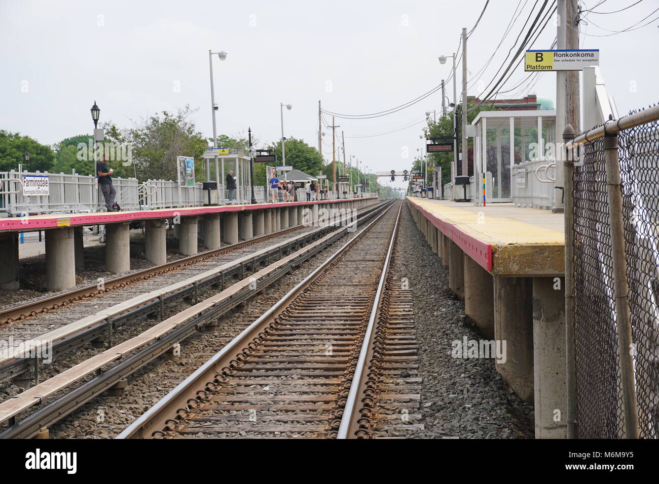 Farmingdale, New York - 4 juin 2016 : à bas la LIRR pistes comme passagers de banlieue attendre un Long Island Railroad train pour aller à Manhattan, New Banque D'Images