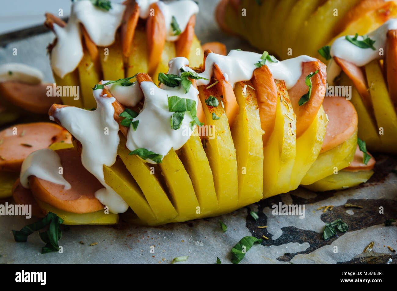 Pommes de terre au four avec de la saucisse et hasselback crème Photo