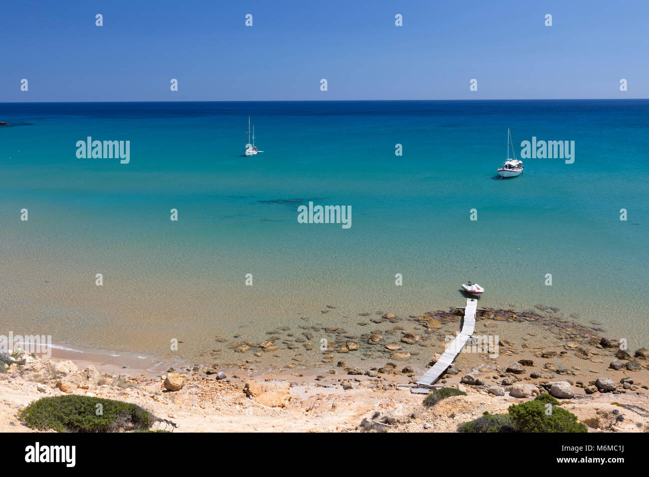 Jetée en bois clair et mer turquoise avec des yachts à Provatas beach, Milos, Cyclades, Mer Égée, îles grecques, Grèce, Europe Banque D'Images