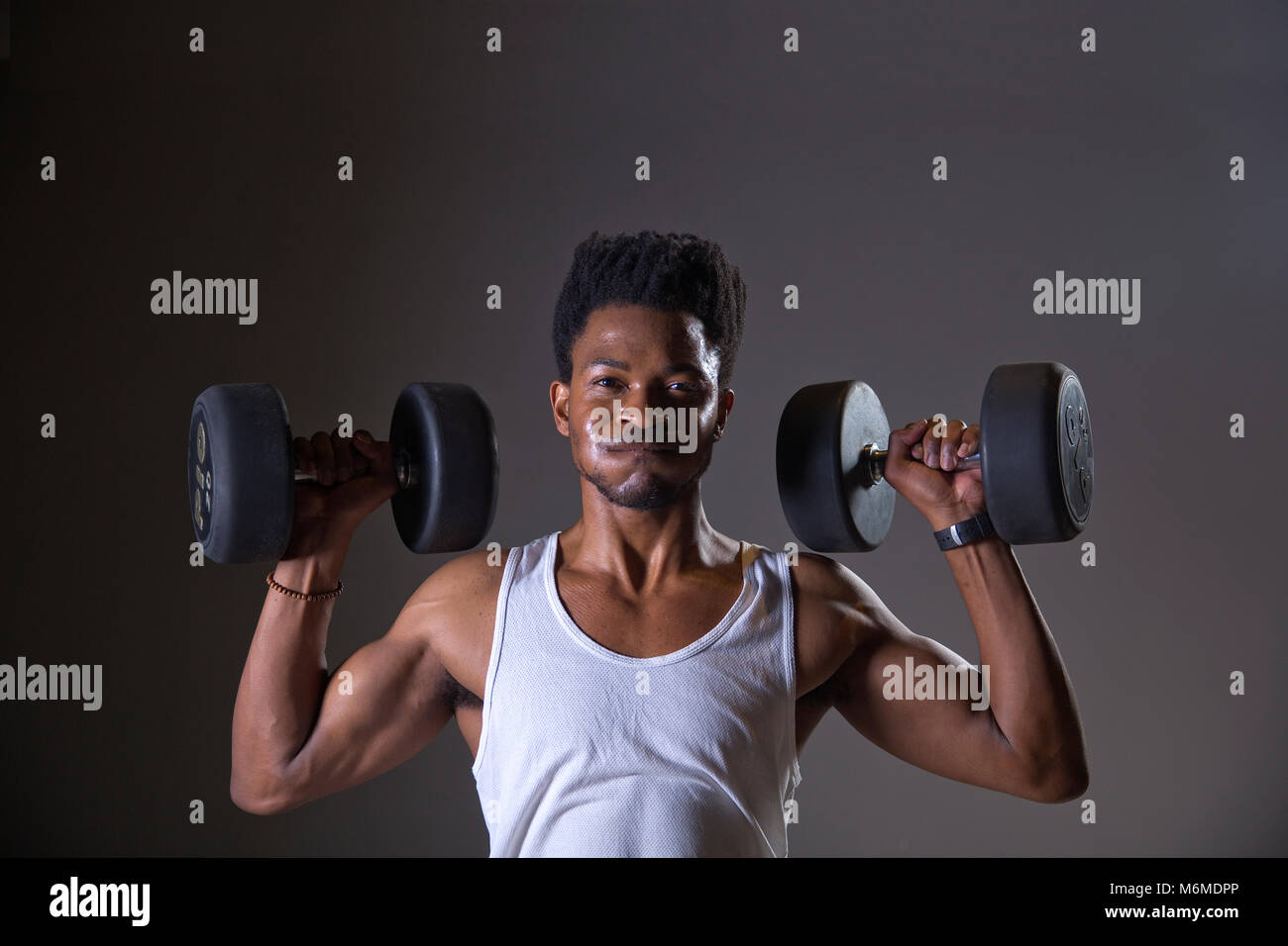 Athlète africain lever des poids dans une salle de sport Banque D'Images