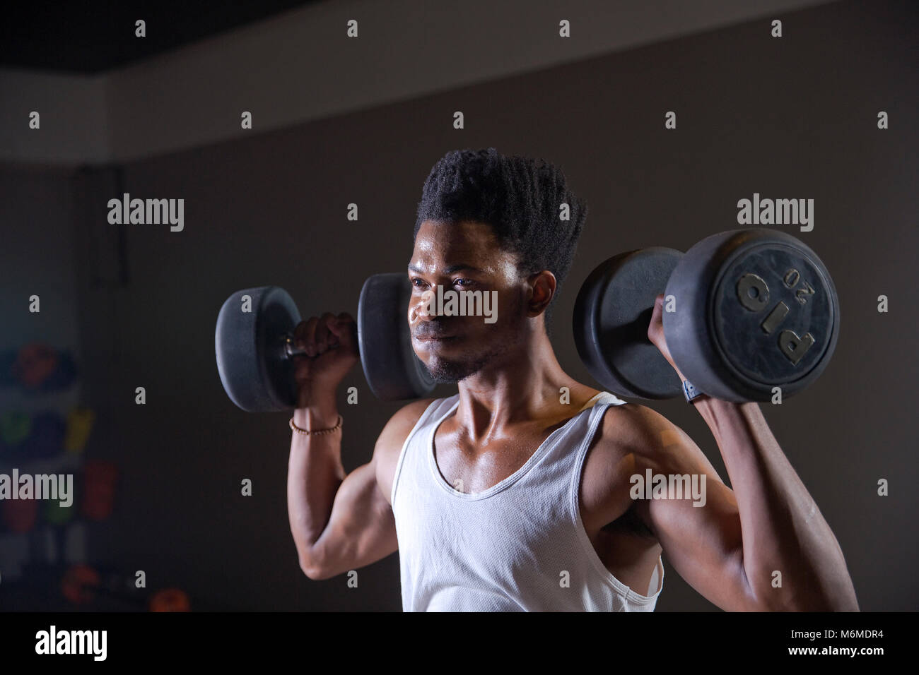 Athlète africain lever des poids dans une salle de sport Banque D'Images