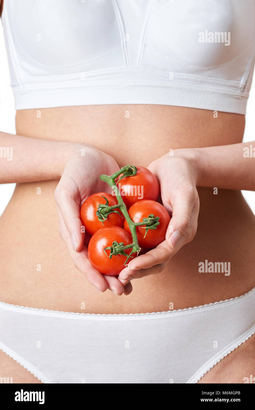 Close Up of Woman in Underwear Holding Tomatoes Banque D'Images