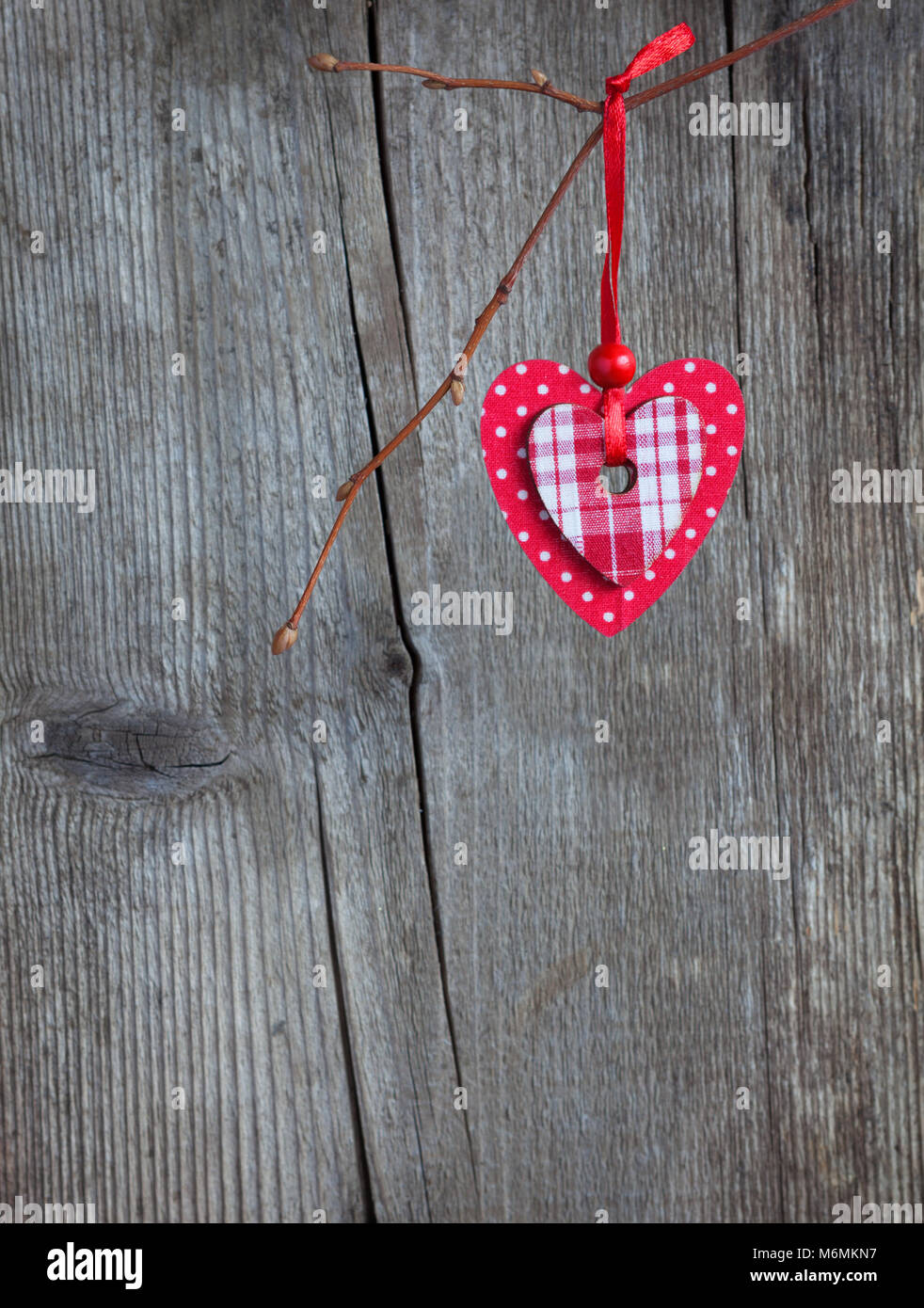 Coeur rouge, suspendu à une branche sur le grunge background. Se concentrer sur le coeur Banque D'Images