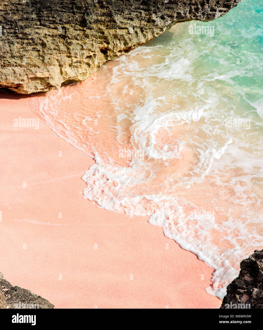 Au clapotis des vagues de la plage de sable rose sur une journée ensoleillée à Long Bay Beach sur la rive sud à Warwick, les Bermudes. Banque D'Images