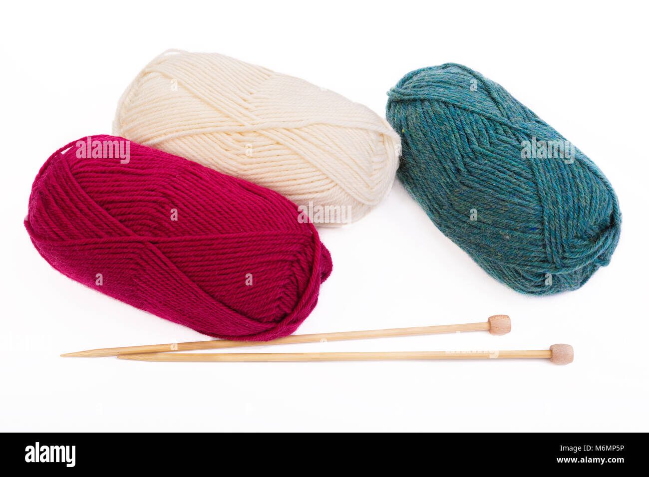 Boules de fils et d'aiguilles à tricoter en bois sur blanc. Banque D'Images