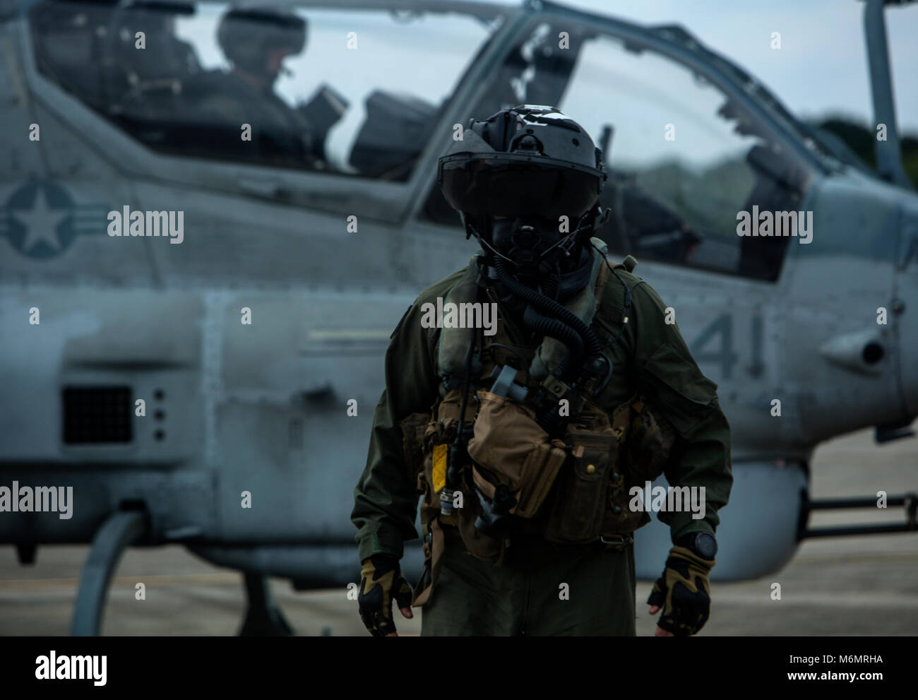 Le Capitaine Justin P. Morrison pas de son AH-1Z Viper à enlever ses équipages de protection mixte Ensemble (JPACE) et l'équipement de protection respiratoire lors d'un événement de formation sur Futenma Marine Corps Air Station, Okinawa, Japon, le 8 février 2018. L'événement de formation était de familiariser les pilotes avec la JPACE. La JPACE permettra d'accroître la protection offerte sur vêtements existants tout en réduisant le stress thermique et le poids du système. L'équipement propre à assurer la protection chimique contre toutes les particules, liquides, vapeurs et aérosols à partir de substances chimiques, biologiques, radiologiques et nucléaires. Morrison est un AH-1Z pilote avec Mar Banque D'Images