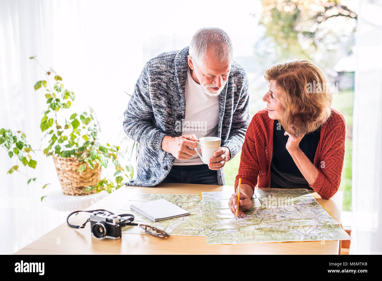 Senior couple with map à la maison, à faire des plans. Banque D'Images