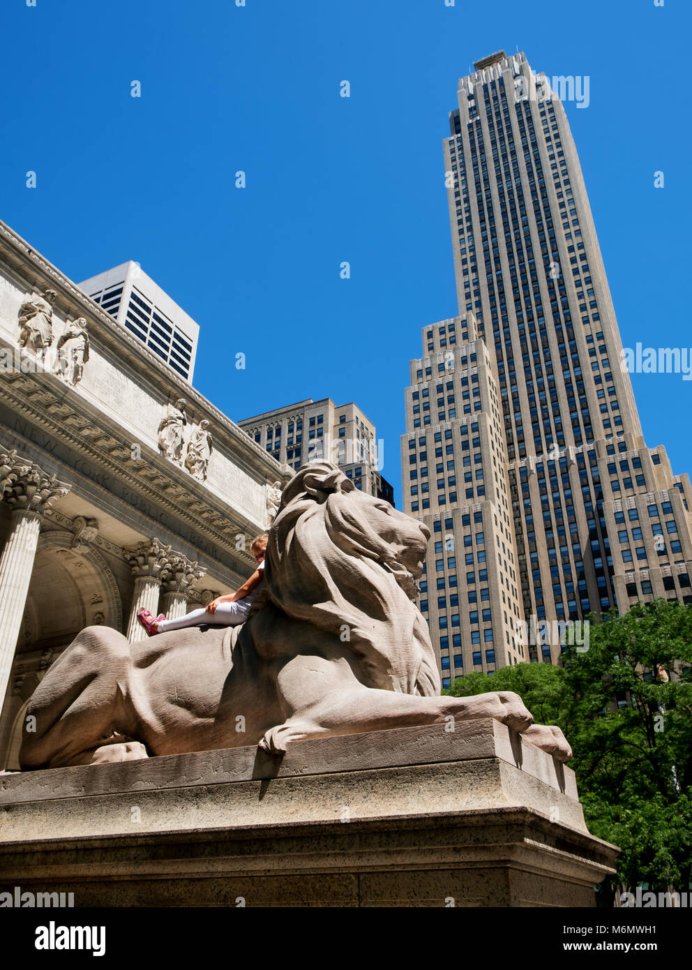 Petite fille sur le lion statue à l'entrée de la Bibliothèque publique de New York Banque D'Images