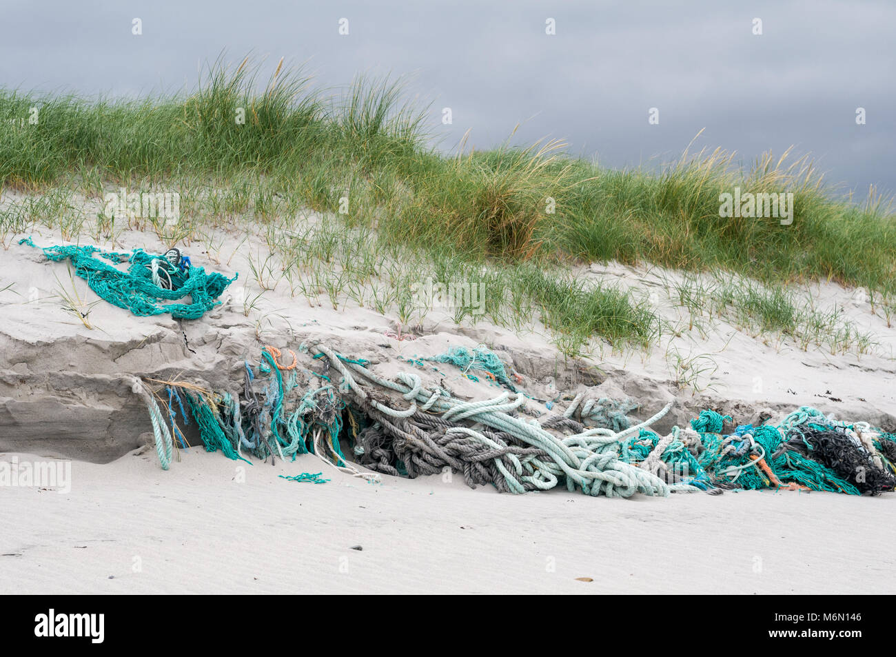 Cordes et filets de pêche abandonné et pris dans la plage et des dunes de sable sur Howmore Beach, South Uist, îles Hébrides, Ecosse, Royaume-Uni Banque D'Images