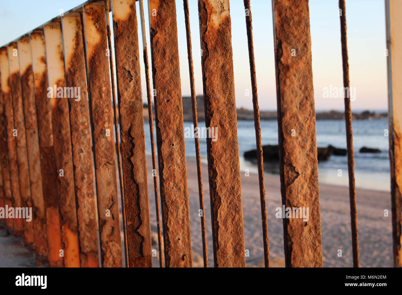 Une clôture rouillée la lumière au coucher du soleil sur une plage à Porto, Portugal Banque D'Images