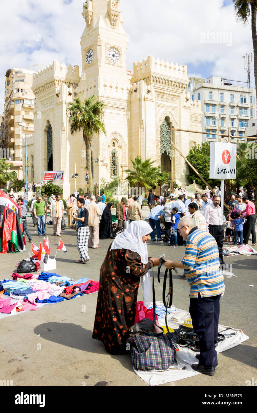 Une femme boutiques pour une courroie à caler dans un marché de rue à
