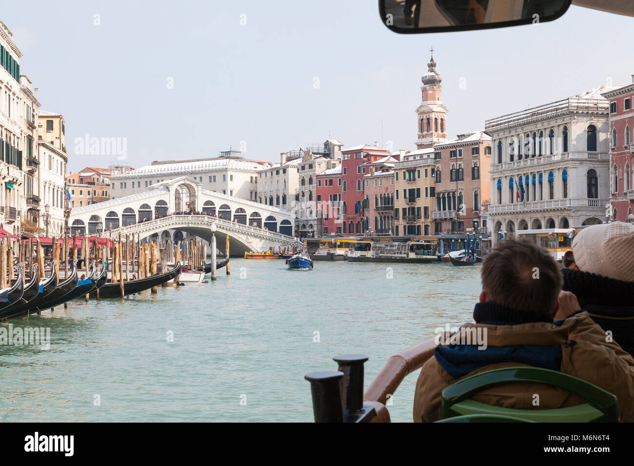 Les touristes voyageant sur un vaporetto sur le Grand Canal près du Pont du Rialto en hiver avec de la neige légère sur les toits dans une première personne POV Banque D'Images