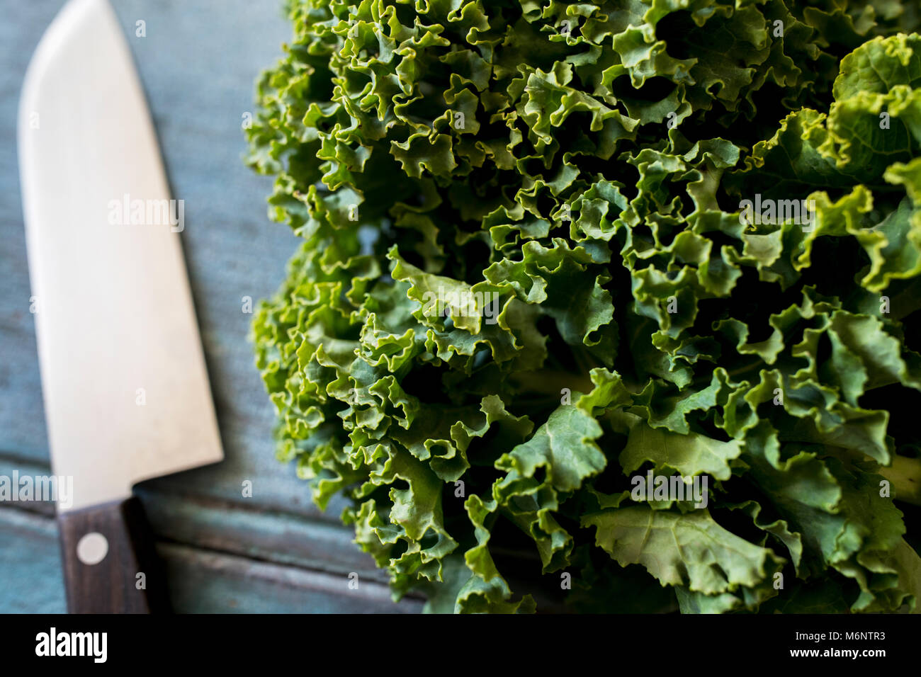 Close Up of Fresh Kale sur table avec couteau Banque D'Images