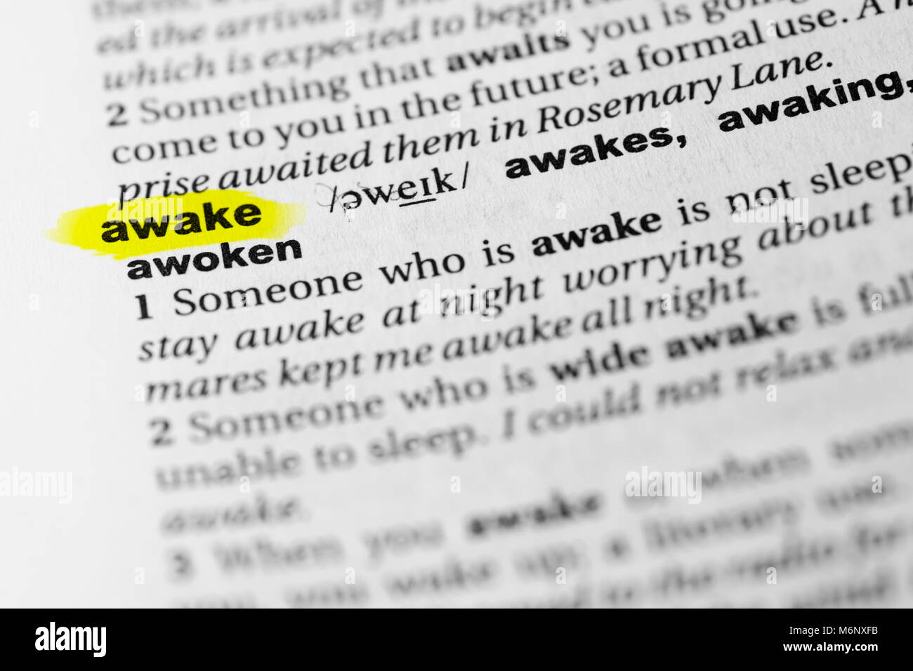 Souligné mot anglais 'éveillé' et sa définition dans le dictionnaire. Banque D'Images