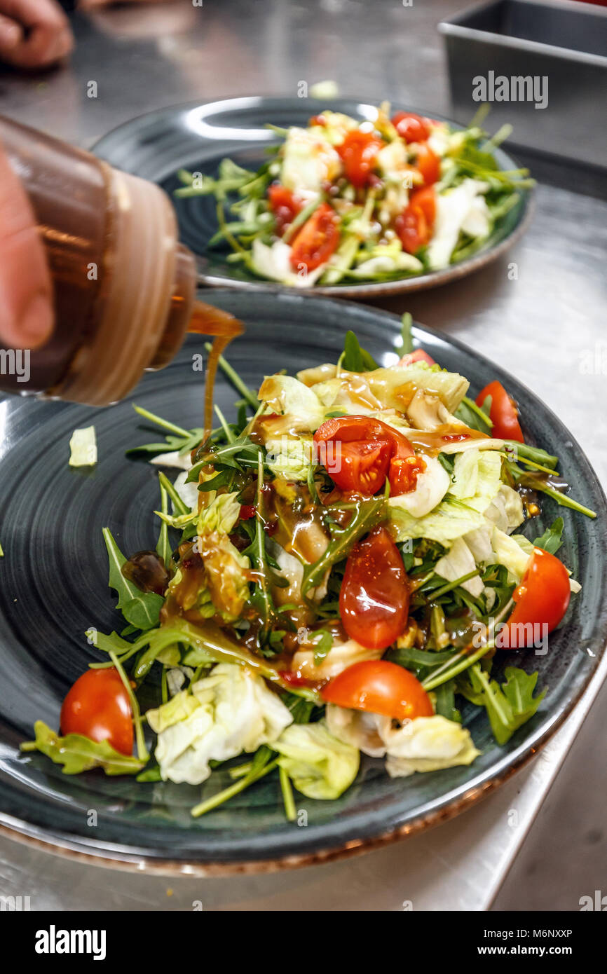 Chef pouring sauce à salade, cuisson, concept de restaurant Banque D'Images