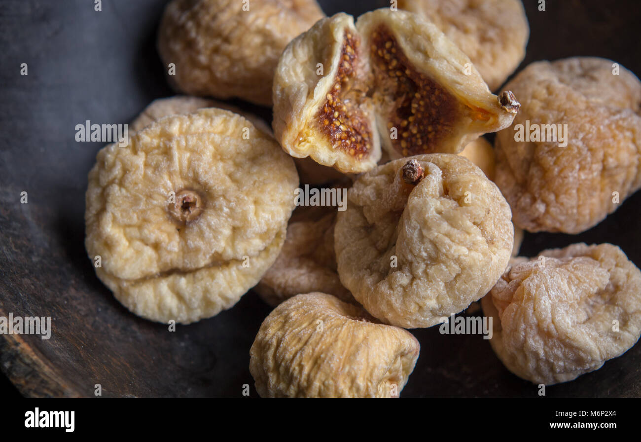 Les figues sèches dans un bol en bois rustique, des fruits secs, fermer l'alimentation à la vie encore Banque D'Images