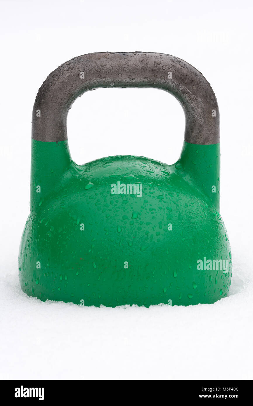 Poids kettlebell formation vert à l'extérieur dans la neige. La concurrence verte kettlebells peser 24 kg. Banque D'Images