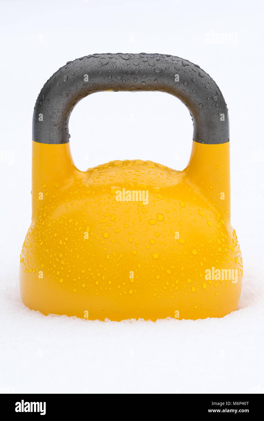 Poids kettlebell formation jaune à l'extérieur dans la neige. La concurrence verte kettlebells pèsent 16 kg. Banque D'Images