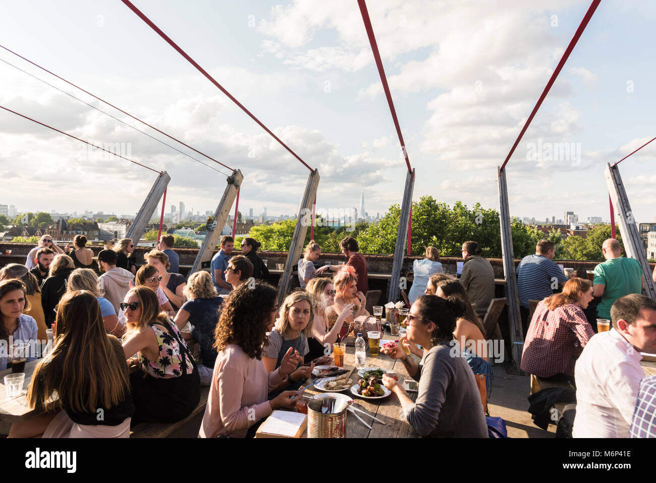 Image sociabilisation des jeunes et de prendre un verre ensemble à Franks Cafe bar restaurant piscine extérieure sur le toit avec vue sur la ville. Banque D'Images