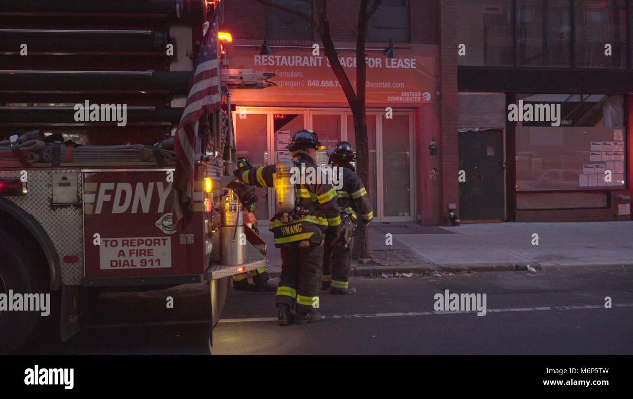 New York - Décembre 2016 : FDNY les Pompiers Pompiers debout à côté d'un camion d'intervention d'urgence en scène dans Lower Manhattan Banque D'Images