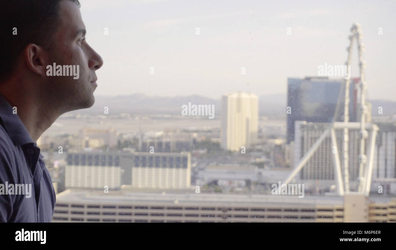 Jeune homme d'affaires à l'hôtel Las Vegas casino resort fenêtre donnant sur skyline pendant la journée Banque D'Images