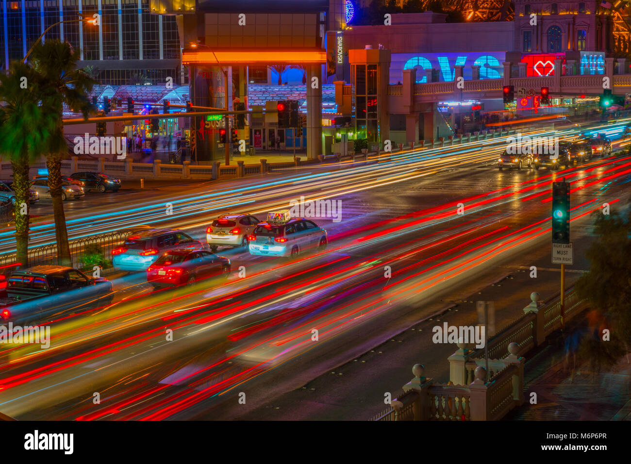 Las Vegas, USA - Circa 2017 : light trails de Las Vegas Blvd du trafic à intersection achalandée. Attendre au feu rouge de taxi et de voiture par zoom. Ph CVS Banque D'Images