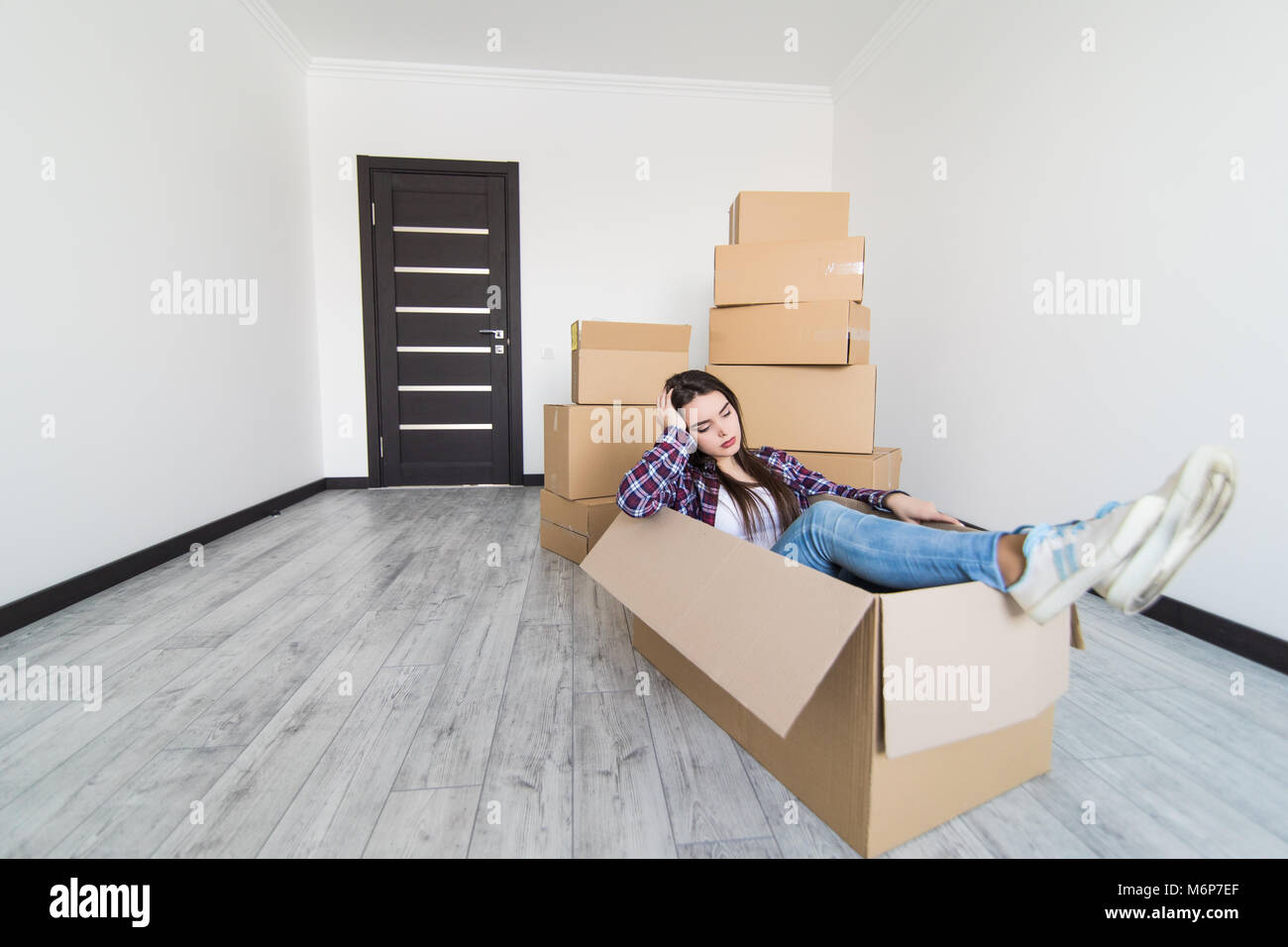 Cheerful woman sitting in a cardboard box Banque D'Images