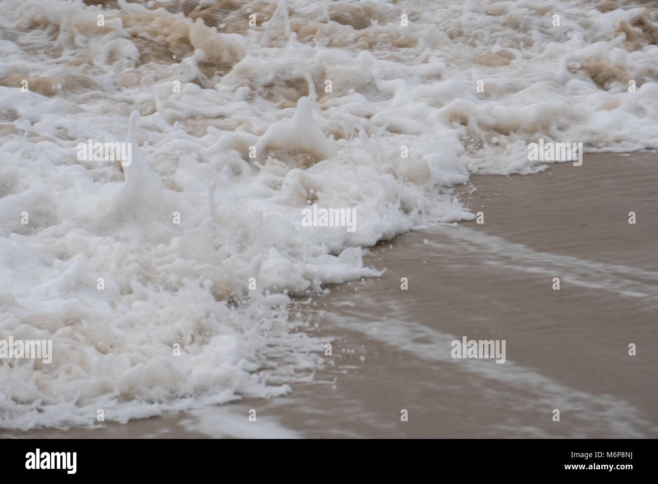 Les vagues de l'océan qui s'écrase sur une plage de sable fin dans la ...