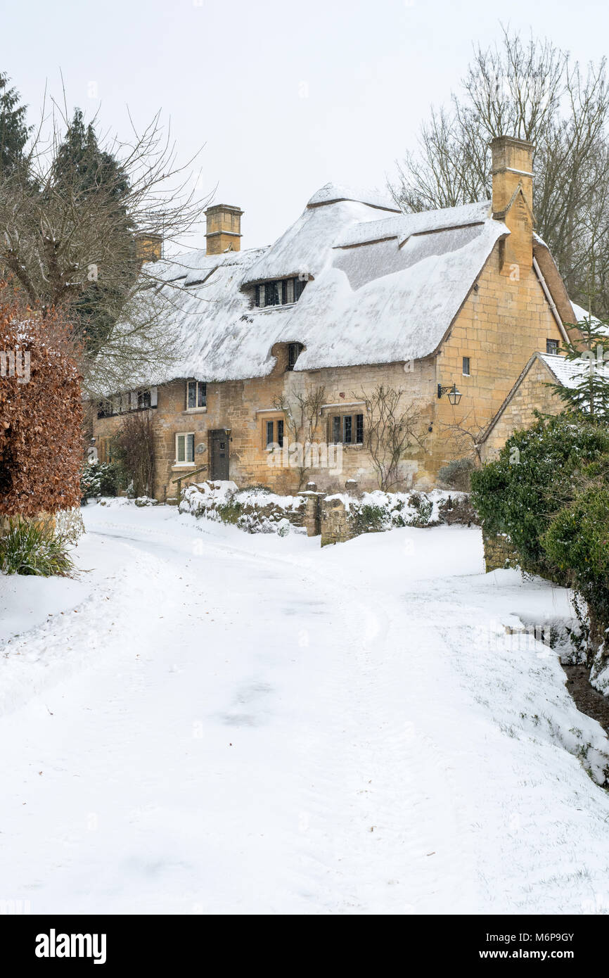 Stanton pierre chaume cottage dans la neige d'hiver. Stanton, Cotswolds, Worcestershire, Angleterre Banque D'Images