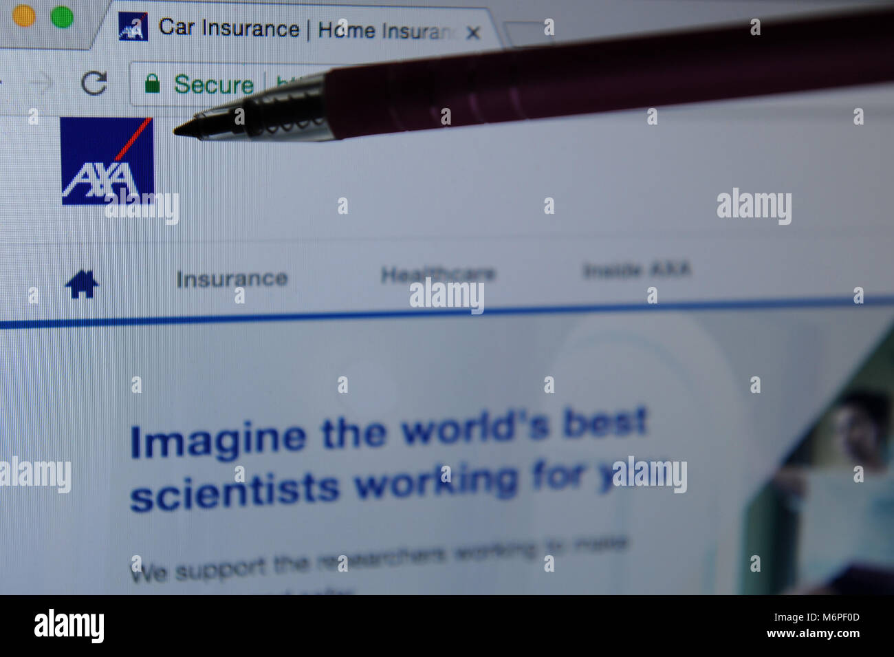 Un stylo pointe vers le logo sur leur site web d'Axa Banque D'Images