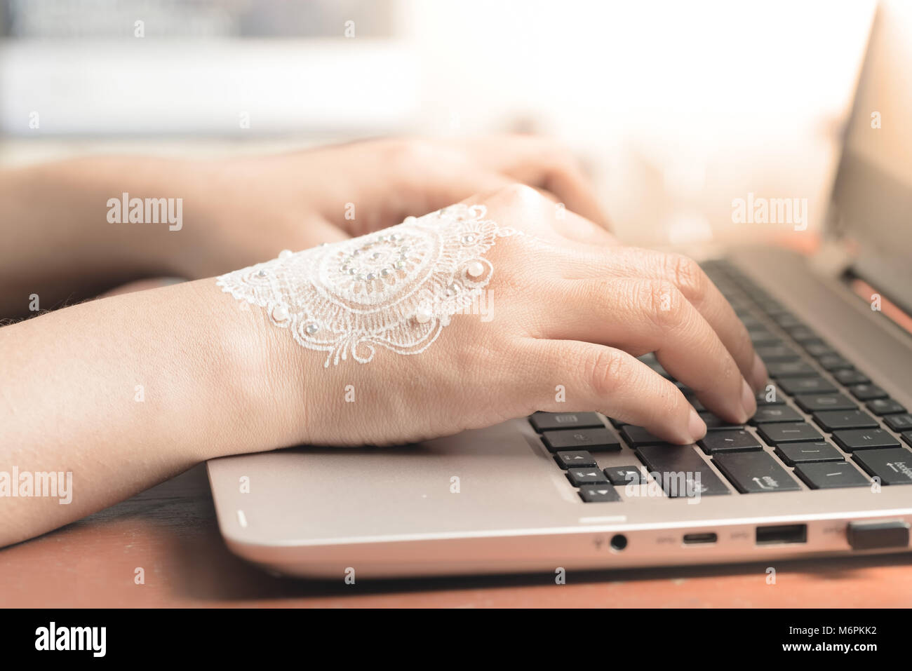La femme de henné la saisie sur clavier d'ordinateur portable. Concept d'entreprise ou d'une femme travaillant à la maison Bureau à la suite de célébration de mariage Banque D'Images