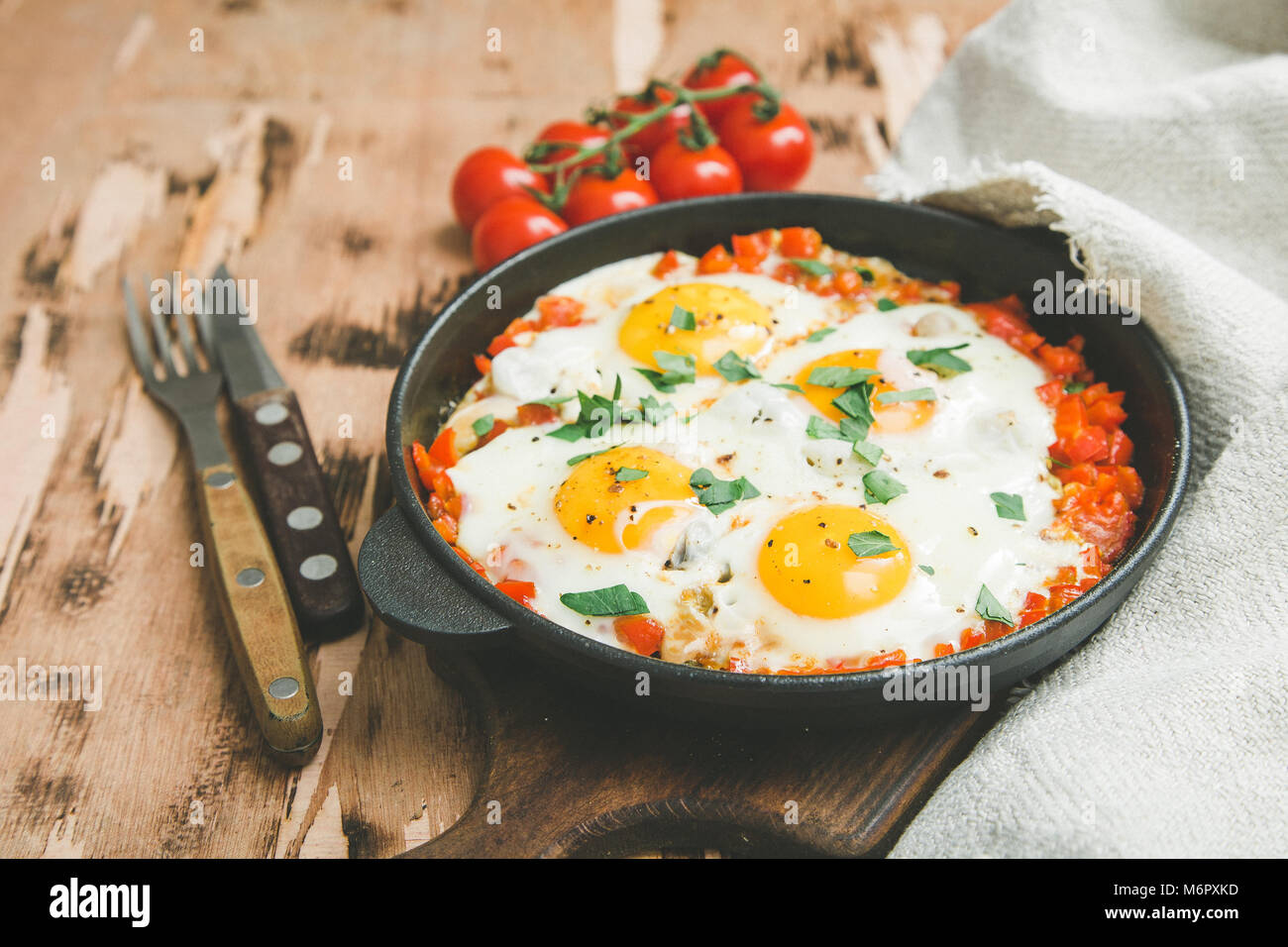 Shakshuka sains et savoureux dans une poêle. Oeufs au plat avec tomates, poivrons, légumes et fines herbes. Plat traditionnel du Moyen-Orient Banque D'Images