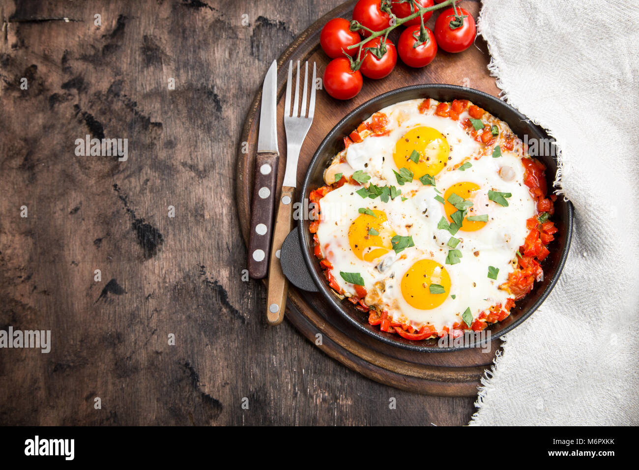 Shakshuka sains et savoureux dans une poêle. Oeufs au plat avec tomates, poivrons, légumes et fines herbes. Plat traditionnel du Moyen-Orient Banque D'Images